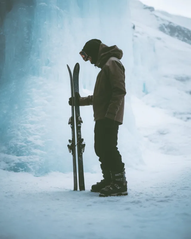 Affiche : skieur debout dans la neige, skis à la main